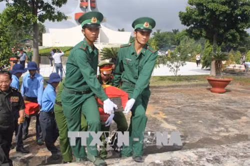 An táng hài cốt các liệt sỹ tại Nghĩa trang liệt sỹ Vĩnh Hưng – Tân Hưng. Ảnh: Bùi Giang – TTXVN