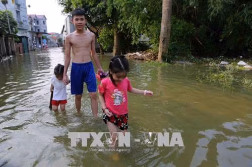 Cuộc sống người dân thôn Muôn vẫn ngập chìm trong nước. Ảnh: Thành Đạt – TTXVN