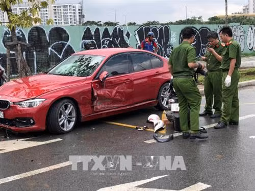Lực lượng công an quận 2 khám nghiệm hiện trường, điều tra nguyên nhân vụ tai nạn. Ảnh: Mạnh Linh-TTXVN