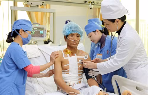Trung tướng Lê Thu Hà (áo trắng, bên phải) cùng các đồng nghiệp khám và chăm sóc sức khỏe cho bệnh nhân sau mổ. Ảnh: Trọng Đức - TTXVN