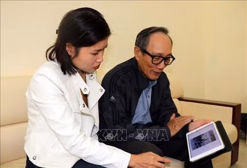 Ông Thường giới thiệu về những bức ảnh đã chụp được trong cuộc chiến chống quân xâm lược bảo vệ biên giới phía Bắc tại Cao Bằng. Ảnh: Quang Đán - TTXVN