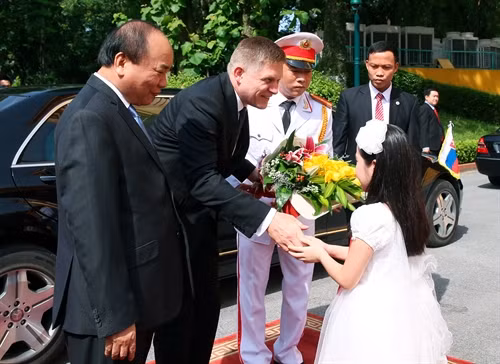 Thiếu nhi Thủ đô tặng hoa Thủ tướng Slovakia, Ngài Robert Fico tại lễ đón. Ảnh:Thống Nhất-TTXVN
