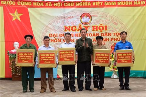 Bộ trưởng Bộ Công an Tô Lâm trao tặng quà các hộ gia đình tiêu biểu, gia đình chính sách trên địa bàn thôn Vĩnh Sơn, xã Vĩnh Phúc. Ảnh: Minh Tâm-TTXVN
