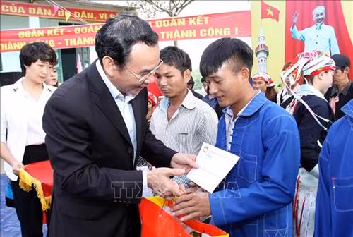 Đồng chí Nguyễn Văn Nên tặng quà các hộ gia đình nghèo trên địa bàn xã A Mú Sung. Ảnh: Quốc Khánh - TTXVN