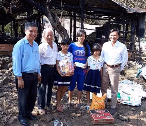 Thầy giáo Nguyễn Tiến Minh thăm và tặng quà cho những em học sinh có hoàn cảnh khó khăn vươn lên trong học tập. Ảnh: Lê Xuân-TTXVN
