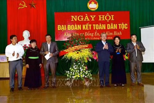 Đồng chí Trần Quốc Vượng tặng hoa chúc mừng cán bộ và nhân dân xã Kim Bình. Ảnh: Quang Cường – TTXVN.
