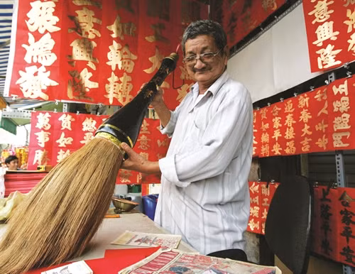 Nhà thư pháp Trương Kiến Quốc (số 213, đường Hải Thượng Lãn Ông, quận 5) - người có thâm niên gần 50 năm trong nghề khoe cây đại bút đề 3 chữ “cẩn thiên bút”
