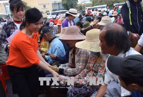 Tặng quà Tết cho người bán vé số về quê sum họp gia đình. Ảnh: Xuân Dự - TTXVN
