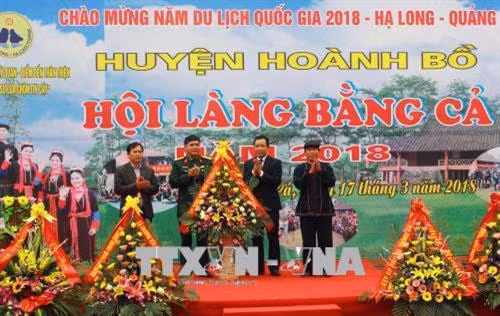 Lãnh đạo địa phương tặng hoa chúc mừng hội làng người Dao. Ảnh: Văn Đức – TTXVN