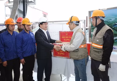 Phó Thủ tướng Trịnh Đình Dũng tặng quà chúc mừng năm mới 2017 cho cán bộ, công nhân đang thi công tuyến đường sắt số 3 Nhổn – Ga Hà Nội. Ảnh: Phương Hoa – TTXVN