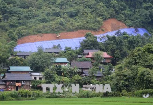 63 hộ dân ở bản Pa Xa Xá (dân tộc Khơ Mú) đang sống dưới cung sạt trượt dài hàng trăm mét trên vách núi phía sau bản. Ảnh: Xuân Tiến-TTXVN