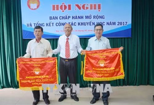 Tặng Cờ thi đua của Trung ương Hội Khuyến học Việt Nam cho 2 tập thể xuất sắc. Ảnh: Hoài Thu – TTXVN.
