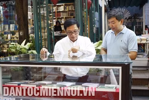 Ông Lê Hoàng, Giám đốc Công ty TNHH Đường sách Thành phố Hồ Chí Minh (bên trái) giới thiệu sách về các giai đoạn hình thành và phát triển của Sài Gòn – Thành phố Hồ Chí Minh với độc giả
