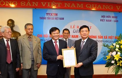 Đồng chí Trần Văn Tuý, Chủ tịch Trung ương Hội hữu nghị Việt Nam - Lào (ngoài cùng bên phải) trao quyết định thành lập Chi hội Hữu nghị Việt Nam - Lào TTXVN cho đồng chí Đinh Đăng Quang, Phó Tổng Giám đốc TTXVN, Trưởng Chi hội Hữu nghị Việt Nam - Lào TTXVN . Ảnh: Thành Đạt/TTXVN