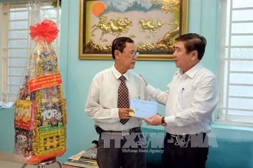 Chủ tịch UBND Thành phố Hồ Chí Minh Nguyễn Thành Phong thăm hỏi và chúc tết tiến sĩ Hồ Hữu Nhựt, ngụ tại huyện Nhà Bè, Thành phố Hồ Chí Minh. Ảnh: Thế Anh-TTXVN