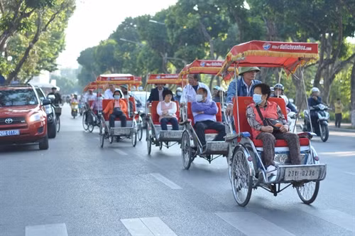 Giữa phố xá đông đúc, những chiếc xích lô vẫn lăn bánh thật chậm rãi.