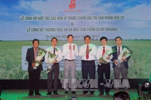 Thứ trưởng Bộ Nông nghiệp và Phát triển nông thôn Trần Thành Nam và Phó Chủ tịch UBND Thành phố Hồ Chí Minh Trần Vĩnh Tuyến tặng hoa chúc mừng Ban Chỉ đạo thương hiệu Co.op Organic. Ảnh: Thanh Vũ – TTXVN.