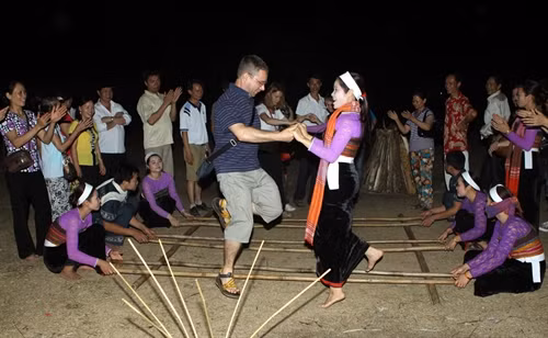 Du khách nước ngoài hòa mình cùng điệu nhảy sạp đặc trưng của dân tộc Thái. Ảnh: Nguyễn Thủy - TTXVN