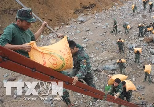 Cán bộ, chiến sĩ Bộ Chỉ huy Quân sự tỉnh Sơn La tham gia vận chuyển gạo cứu trợ người dân vùng lũ. Ảnh: TTXVN phát.
