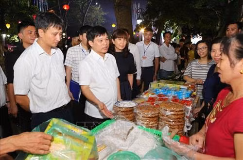 Ông Ngô Văn Quý, Phó Chủ tịch UBND thành phố Hà Nội cùng các đại biểu tham quân các gian hàng ẩm thực. Ảnh: Thành Đạt – TTXVN