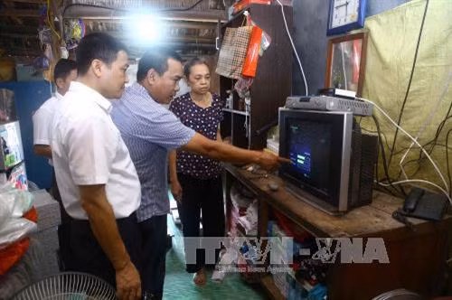 Lắp đặt đầu thu truyền hình số mặt đất tại hộ gia đình. Ảnh: Minh Quyết - TTXVN