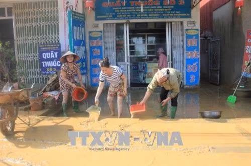 Người dân nỗ lực khắc phục hậu quả do mưa lũ. Ảnh: Tạ Toàn - TTXVN