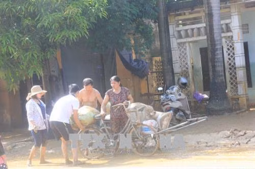 Người dân nỗ lực khắc phục hậu quả do mưa lũ. Ảnh: Tạ Toàn - TTXVN