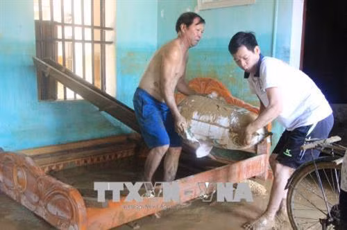 Người dân nỗ lực khắc phục hậu quả do mưa lũ. Ảnh: Tạ Toàn - TTXVN