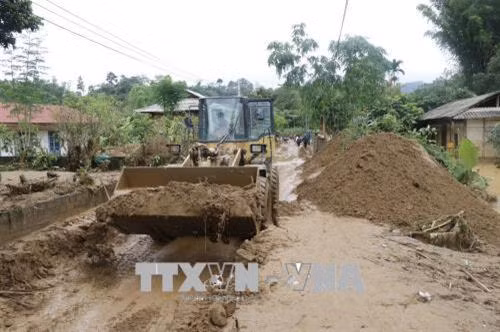 Các phương tiện, máy móc được huy động tham gia dọn đường vào bản Mười, xã Sơn Lương, huyện Văn Chấn. Ảnh: Việt Dũng - TTXVN