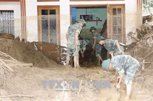 Các chiến sỹ Trung đoàn 98, Sư đoàn 316 (Quân khu 2) giúp người dân bản Mười, xã Sơn Lương, huyện Văn Chấn khắc phục hậu quả mưa lũ. Ảnh: Việt Dũng - TTXVN