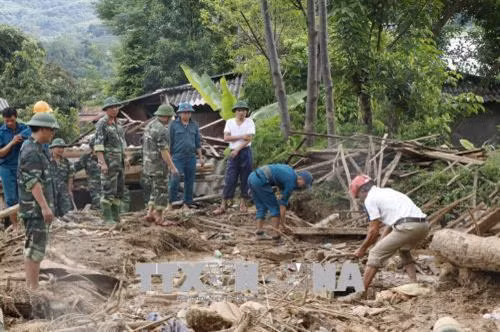 Lực lượng chức năng giúp người dân bản Tủ, xã Sơn Lương, huyện Văn Chấn khắc phục hậu quả mưa lũ. Ảnh: Việt Dũng - TTXVN