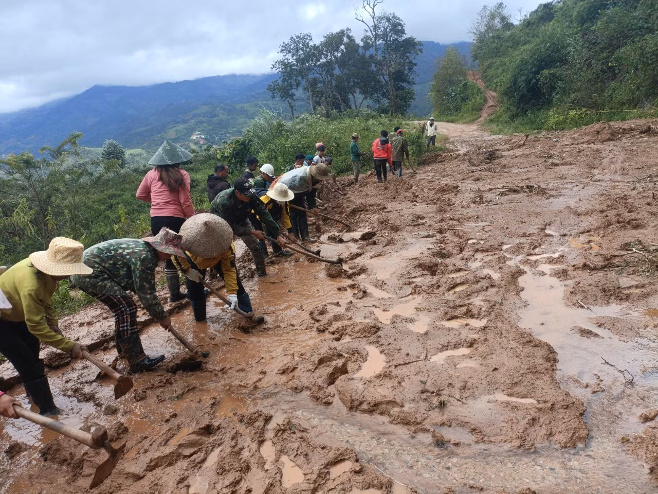Hơn 100 người dân thôn Tu Thó (xã Tê Xăng, huyện Tu Mơ Rông, tỉnh Kon Tum) phối hợp với chính quyền địa phương khắc phục vị trí bị sạt lở do mưa to hồi cuối tháng 9/2022. Ảnh: TTXVN phát