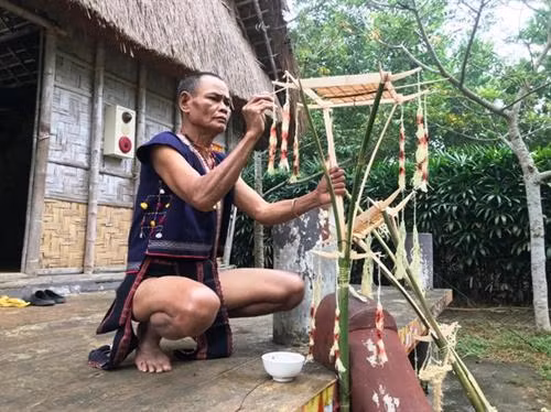 Thày cúng bôi tiết vào cây nêu.