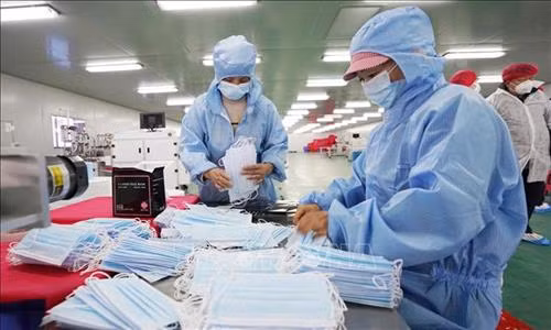Công nhân kiểm tra sản phẩm tại nhà máy sản xuất khẩu trang y tế ở thành phố Trùng Khánh, Trung Quốc ngày 27/1/2020. Ảnh: THX/TTXVN