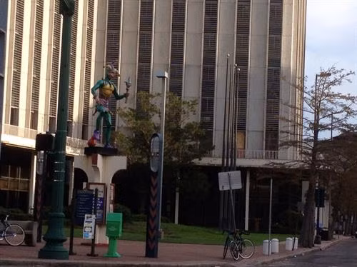 Chú hề khổng lồ đặt phía trước một tòa cao ốc. Du khách trên đường phố New Orleans.