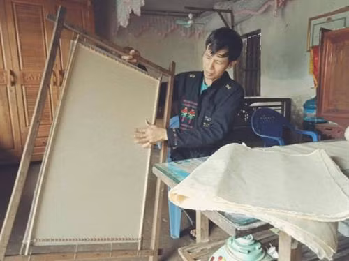 Anh Quang làm các bước cuối cùng để hoàn thiện một bản giấy dó. Ảnh: Long Vũ