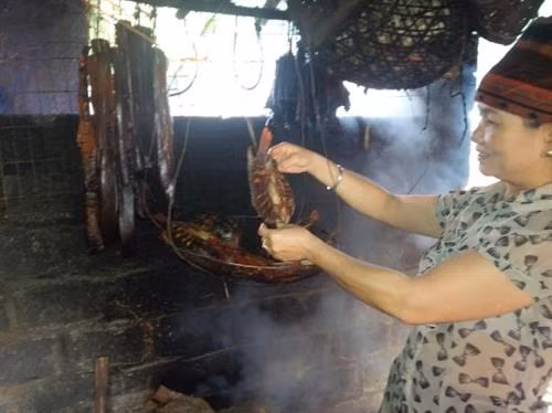 Vợ ông Pổn sấy cá sỉnh để đãi khách quý. Ảnh: Nhật Thanh