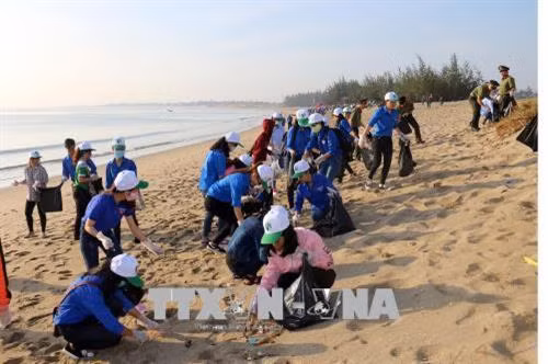 Đoàn viên, thanh niên tỉnh Ninh Thuận chung tay thu gom rác thải dọc bãi biển Bình Sơn-Ninh Chử. Ảnh: Công Thử - TTXVN
