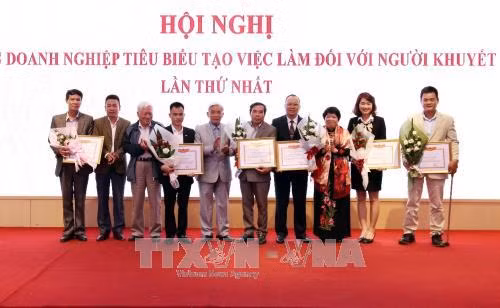 Trao Bằng khen cho 12 doanh nghiệp tiêu biểu trong tạo việc làm cho người khuyết tật. Ảnh: Anh Tuấn – TTXVN