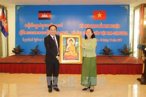 Bà Touch Sarom, Quốc vụ khanh Bộ Lễ nghi và Tôn giáo Campuchia tặng quà lưu niệm cho Ban Tôn giáo Chính phủ Việt Nam. Ảnh: Ngọc Thiện- TTXVN