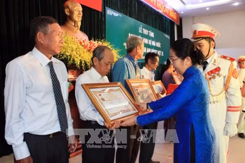 Bà Võ Thị Dung, Phó Bí thư Thành ủy Thành phố Hồ Chí Minh, trao danh hiệu "Bà mẹ Việt Nam Anh hùng" cho đại diện gia đình các Mẹ. Ảnh: Nguyễn Xuân Khu - TTXVN