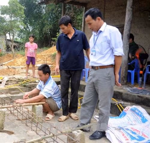 Ông Phạm Ngọc Duẫn, kiểm tra việc xây dựng nhà mới cho gia đình anh Sầm Văn Môn, thôn Tân Phú, xã Đại Phú. Ảnh Quang Đán - TTXVN.