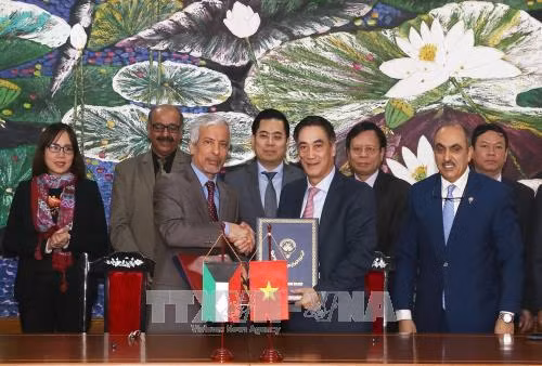 Ông Trần Xuân Hà, Thứ tưởng Bộ Tài chính (bên phải) và ông Hesham Al-Waqayan, Phó Tổng giám đốc Quỹ Kuwait về Phát triển kinh tế Arab ký hiệp định. Ảnh: Phạm Hậu-TTXVN