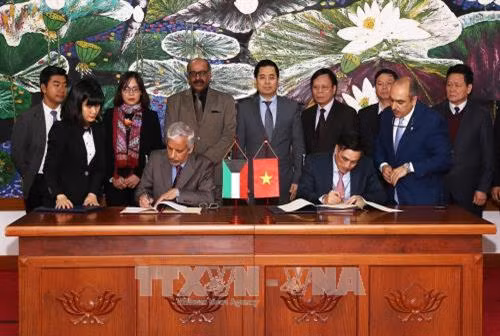 Ông Trần Xuân Hà, Thứ tưởng Bộ Tài chính (bên phải) và ông Hesham Al-Waqayan, Phó Tổng giám đốc Quỹ Kuwait về Phát triển kinh tế Arab ký hiệp định. Ảnh: Phạm Hậu-TTXVN