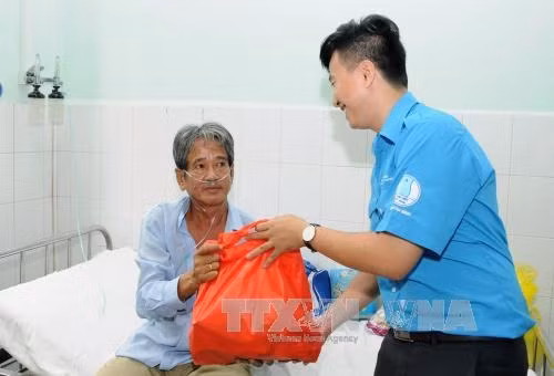 Các đoàn viên thanh niên trao tặng quà Tết cho bệnh nhân tại Bệnh viên Phạm Ngọc Thạch Ảnh: An Hiếu - TTXVN