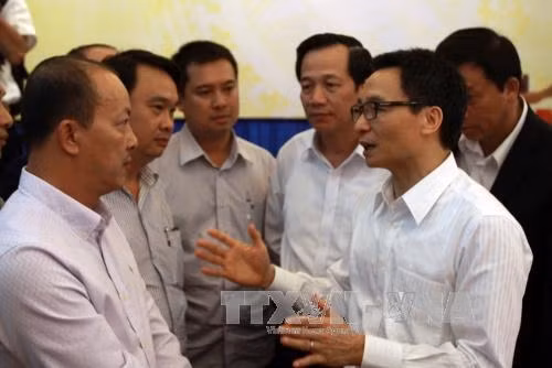 Phó Thủ tướng Vũ Đức Đam trao đổi với các đại biểu bên lề hội nghị. Ảnh: Phương Vy – TTXVN