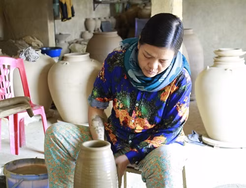 Người dân làng nghề đang tạo hình gốm.