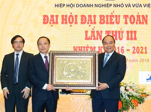 Thủ tướng Nguyễn Xuân Phúc tặng bức tranh cho Hiệp hội Doanh nghiệp nhỏ và vừa Việt Nam. Ảnh: Thống Nhất-TTXVN