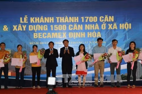 Các gia đình công nhân được nhận giấy chứng nhận quyền sử dụng nhà. Ảnh: Nguyễn Văn Việt - TTXVN