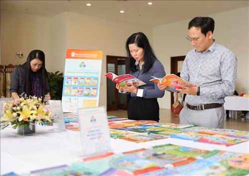 Đại biểu dự hội thảo xem các bản mẫu sách giáo khoa do Nhà xuất bản Giáo dục Việt Nam biên soạn. Ảnh: Thanh Tùng – TTXVN